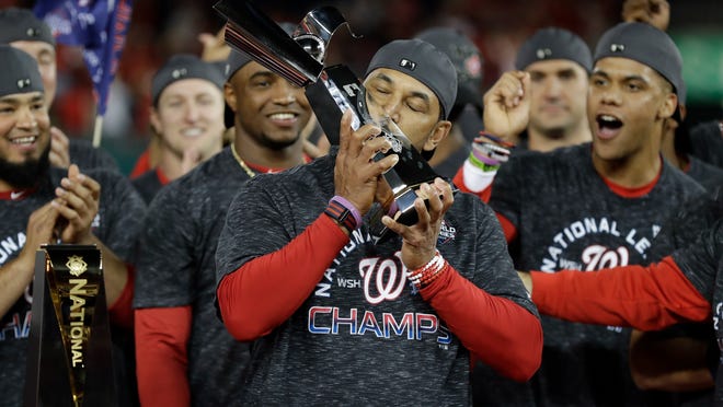 Washington Nationals manager Dave Martinez kisses the NLCS trophy after Game 4 of the baseball National League Championship Series against the St. Louis Cardinals Tuesday, Oct. 15, 2019, in Washington. The Nationals won 7-4 to win the series 4-0. (AP Photo/Jeff Roberson)