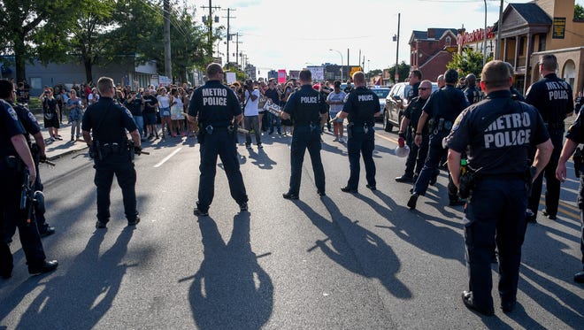 Protesters encounter police in the center of Broadway, at Shelby St, during a Black Lives Matter protest in Louisville, Ky., Sunday, August 13, 2017.  The march was allowed to continue using the sidewalk.
