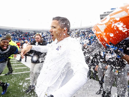 Memphis head coach Mike Norvell (middle) gets a dumped