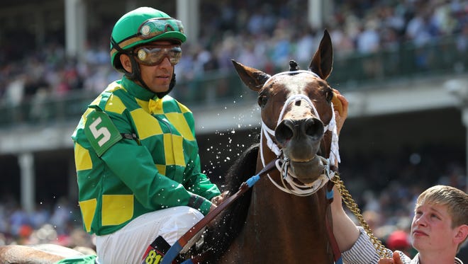 Finnegans Wake is cooled off after the race while jockey Victor Espinoza keeps an eye on his wiining horse.  May 2, 2015.