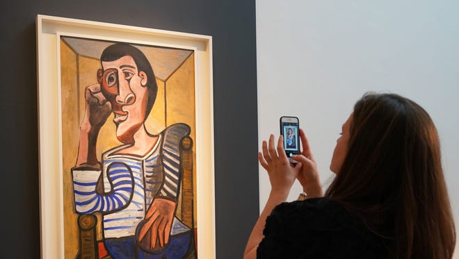 A Christie's employee takes a picture of Pablo Picasso's Le Marin during a media preview at Christie's May 3, 2018 in New York.