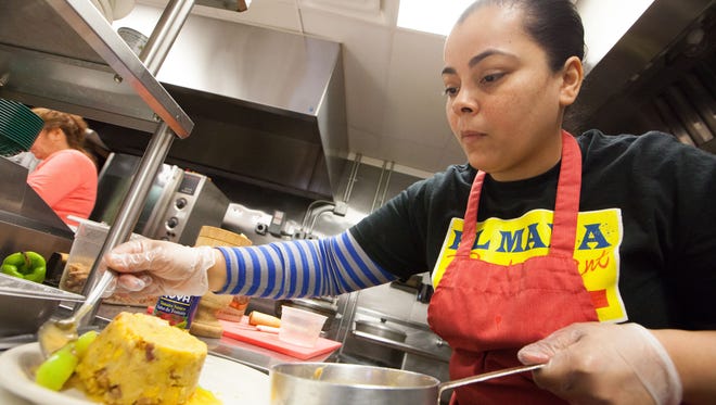 Alexsandra Rodriquez, owner of El Mana in Wilmington, prepares a dish on Wednesday. The area has an increasing number of international eateries.