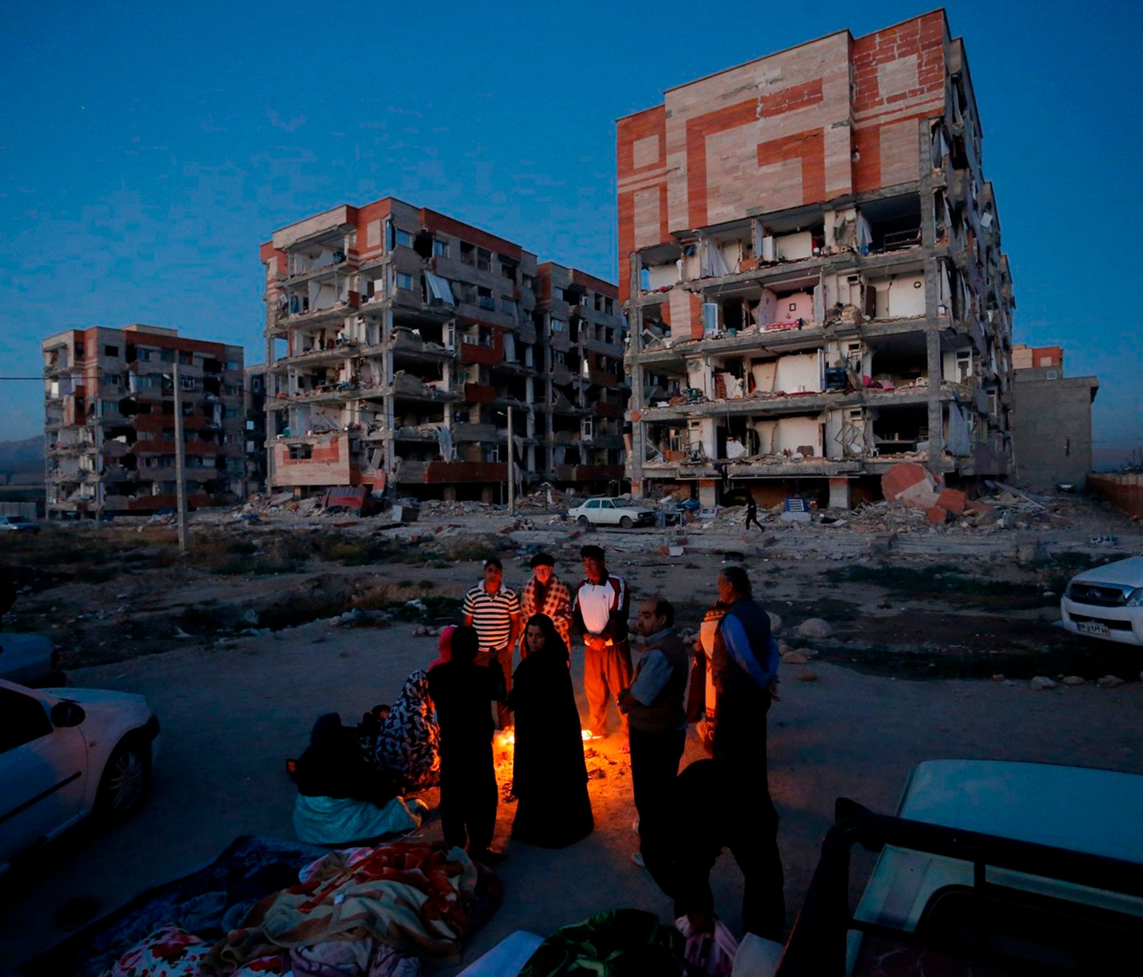 Residents huddle by a fire in an open area following an earthquake at Sarpol-e Zahab in Iran's Kermanshah province on Nov. 13, 2017.