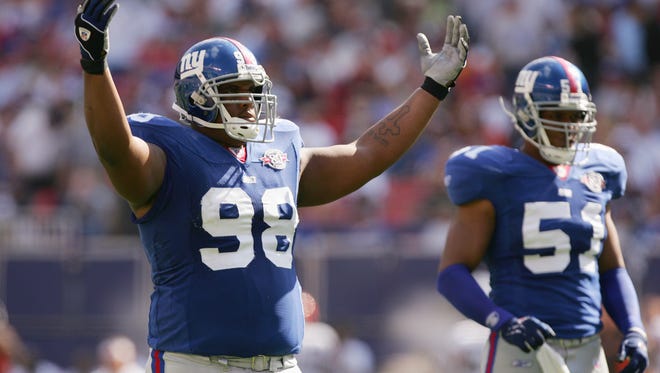 New York Giants defensive tackle Fred Robbins #98 reacts as teammate Carlos Emmons #51 looks on during the game against the Cleveland Browns at Giants Stadium on September 26, 2004 in East Rutherford, New Jersey. The Giants defeated the Browns 27-10.