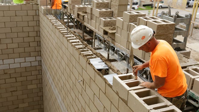 Brandon Clausen of Pahlow Masonry levels out a block that is in a stairwell of the Oshkosh Arena.  Construction crews from Bayland Buildings were setting the bleacher area and Pahlow Masonry continues to work on the masonry work at the Oshkosh Arena Friday, August 18, 2017.  The Oshkosh Arena is expected to be completed by November of 2017 and it will be the home of the Milwaukee Bucks G-League team the Wisconsin Herd.Joe Sienkiewicz / USA TODAY NETWORK-Wisconsin