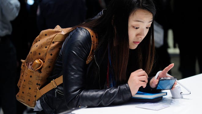 A visitors looks at a Samsung Galaxy S4 at the Mobile World Congress in Barcelona, on February 24, 2014. Many apps that turn your smartphone camera in to a search engine are available for Android and iPhones.