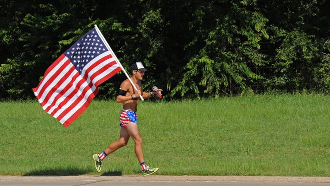 People carry U.S. flags on Bossier City's Arthur Ray Teague Parkway in a recent race.