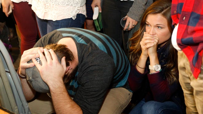 From left, Colten Christenen and Abby Schafer react in disbelief after learning that TCU will not be one of the four teams in the NCAA College Football Playoff at a watch party at the Aardvark near the TCU campus Sunday.