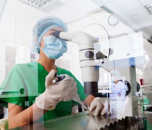 Scientist looking at microscope cancer research