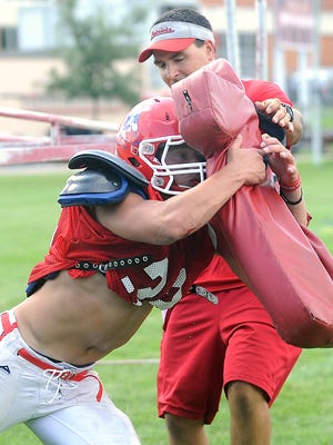 Running back Braxton Large works on drills with defensive coordinator Brian Bechard during football practice at Lincoln High School in Sioux Falls, S.D., Monday, Aug., 18, 2014.