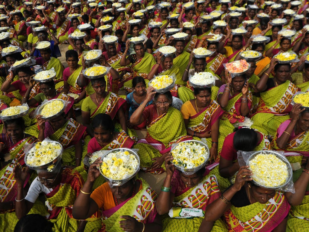 Indian women carry plates of flowers as a symbolic offering during a ceremony for the victims of the 2004 tsunami at Marina Beach in Chennai on Dec. 26, 2016. The earthquake and tsunami that struck the Indian Ocean killed over 230,000 people and deva