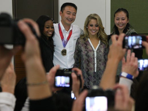 Gabby Douglas, Liang Chow, Shawn Johnson, and Chows wife Liwen Zhuang Posed for photos after the awards ceremony. October 12, 2012 - Des Moines, Iowa - A private reception for coach Chow at which Steve Penny CEO of USA Gymnastics honored him with his own "gold metal" . (Andrea Melendez/The Register)