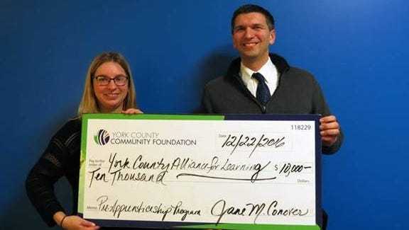 Community Investment Officer for York County Community Foundation Elyse Pollick, left, poses with the York County Alliance for Learning Executive Director Kevin Appnel. The two hold a grant given to the York County Alliance for Learning from the York County Community Foundation.