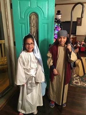Keeli Villarreal and Diego Benavides portray Mary and Joseph in a posada celebrating the birth of Jesus.