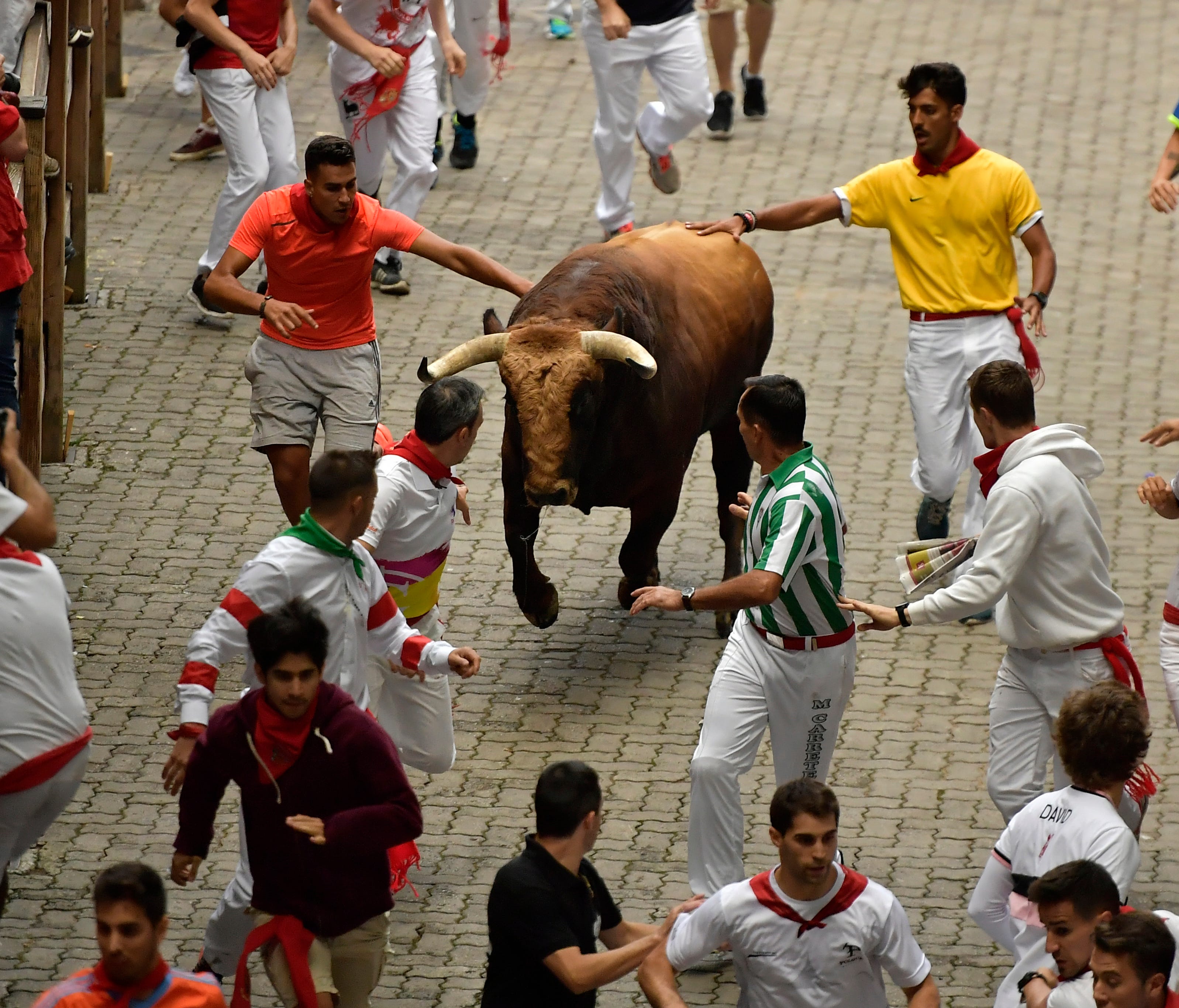 Revellers run in front of a Puerto de San Lorenzo fighting bull during the third running of the bulls at the San Fermin Festival, in Pamplona, Spain, on July 9, 2017. Revelers from around the world flock to Pamplona every year to take part in the eig