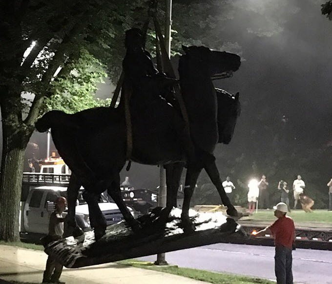 Workers load statues of Confederate generals Robert E. Lee and Thomas 