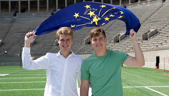Harvard sophomores Nick Bayh (left) and Beau Bayh hold aloft the Indiana state flag in Harvard Stadium. The twins are the sons of former Indiana Sen. Evan Bayh.
