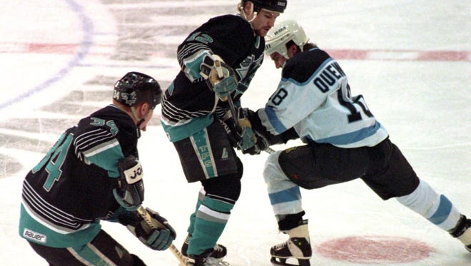 Chad Quenneville of the Nashville Knights fights for the puck against Knoxville defenders Mike Vanderberghe, left, and Shaun Hannah during a game in 1996.