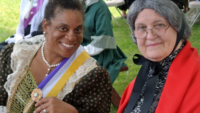 Barbara Blaisdell (right), portraying Susan B. Anthony, sits with Ida B. Wells (portrayed by Michelle Huckaby) at an event hosted by the Susan B. Anthony Museum & House.