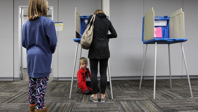 Terri Davies votes at the North Liberty Community Center with help from her 6-year-old son, Hudson, and 11-year-old daughter, Laina, on Tuesday, Nov. 8, 2016. 