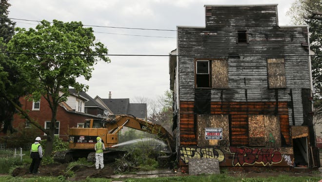 City of Detroit Construction Services workers tear down an abandoned structure across from Bennett Elementary School in Detroit on Thursday May 12, 2016. Teachers, parents and community organizers pushed to have vacant buildings demolished near the school in southwest Detroit worried when body was found in the vacant rooming house across from school