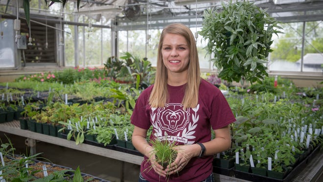 Graduate Student Jerri Lynn Dodson poses in the Karls Hall greenhouse.
