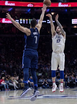 Philadelphia 76ers' JJ Redick, right, shoots the three-point basket as Dallas Mavericks' Dwight Powell, left, defends during the second half of an NBA basketball game Sunday, April 8, 2018, in Philadelphia.