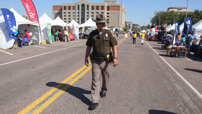 Mauricio Aguilera, an Iowa State trooper, walks the grounds around the Latino Heritage Festival on Saturday, Sept. 26, in Des Moines.