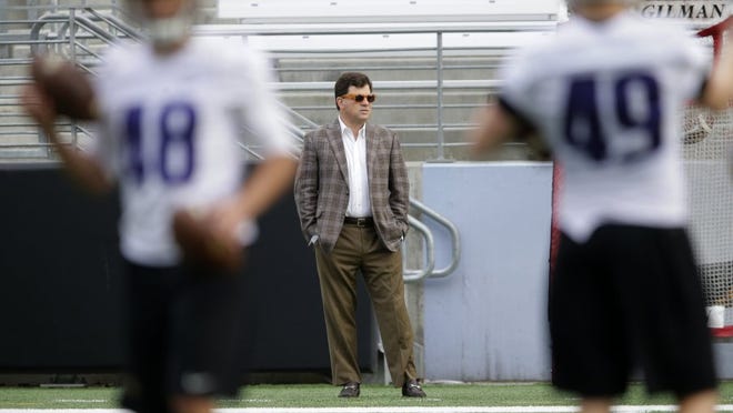Former Washington and Texas A&M athletic director Scott Woodward, center, watches from the sideline as players take part in practice drills, Monday, March 30, 2015, on the first day of spring NCAA college football practice in Seattle.
