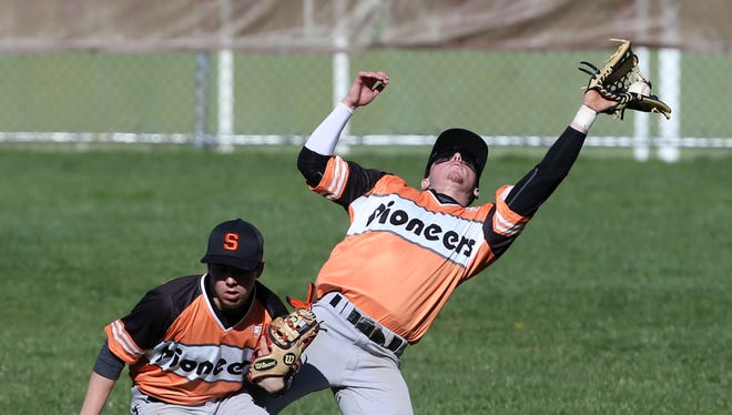 Somerville's Preston Scott  (right) has the ball go off his glove as he collides with teammate  Ethan Lott (left) as both try for a pop up on April 5.