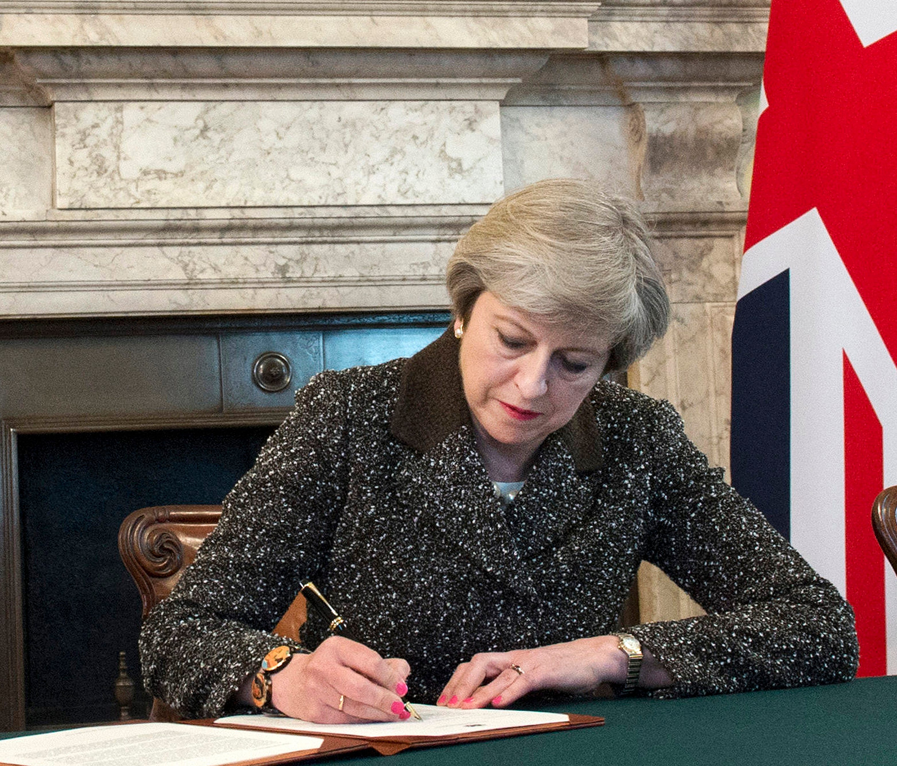 A handout photo made available by 10 Downing Street on March 29, 2017 shows British Prime Minister Theresa May signing a letter of notification to the President of the European Council setting out the United Kingdom's intention to withdraw from the E