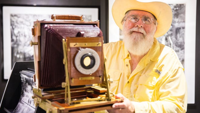 Clyde Butcher stands for a portrait next to his camera in his Big Cypress Gallery during the third annual Fall Festival at on Oct. 28, 2017. It was his first public appearance since suffering from a stroke earlier this year.