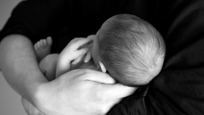 A parent holds a newborn baby.