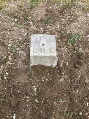 A granite survey marker at the Port Clinton Lighthouse bearing the initials of the United States Lighthouse Establishment.