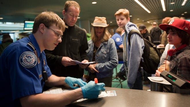 Passengers line up to a Transportation Security Administration (TSA) officer to go through airport security at Portland International Airport (PDX) March 19, 2012 in Portland, Oregon.