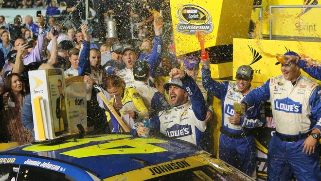 Jimmie Johnson (48) celebrates after winning the NASCAR Sprint Cup Series and Ford EcoBoost 400 Championship on Sunday, at Homestead-Miami Speedway.