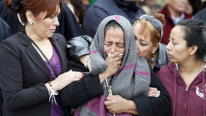 Agapita Montes-Rivera, center, the mother of Antonio Zambano-Montes, is comforted following the funeral for her son.