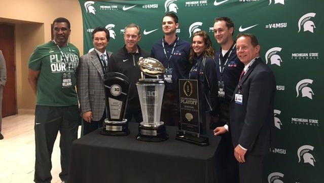 Michigan State coach Mark Dantonio, third from left, and others pose Wednesday in Detroit with trophies for winning the Big Ten East, the Big Ten championship game and making it to the College Football Playoff.