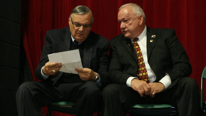 Maricopa County Sheriff Joe Arpaio (left) talks with Russell Pearce at an Arizona Red Mountain tea party meeting at East Valley High school in Mesa on March 19, 2012.