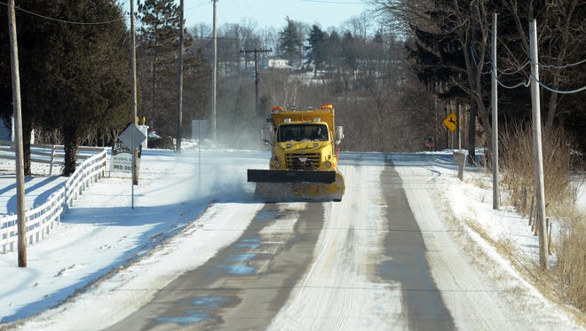 A plow is used to move snow and ice from Indiana 227 South.