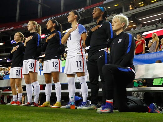 Megan Rapinoe #15 kneels during the national anthem