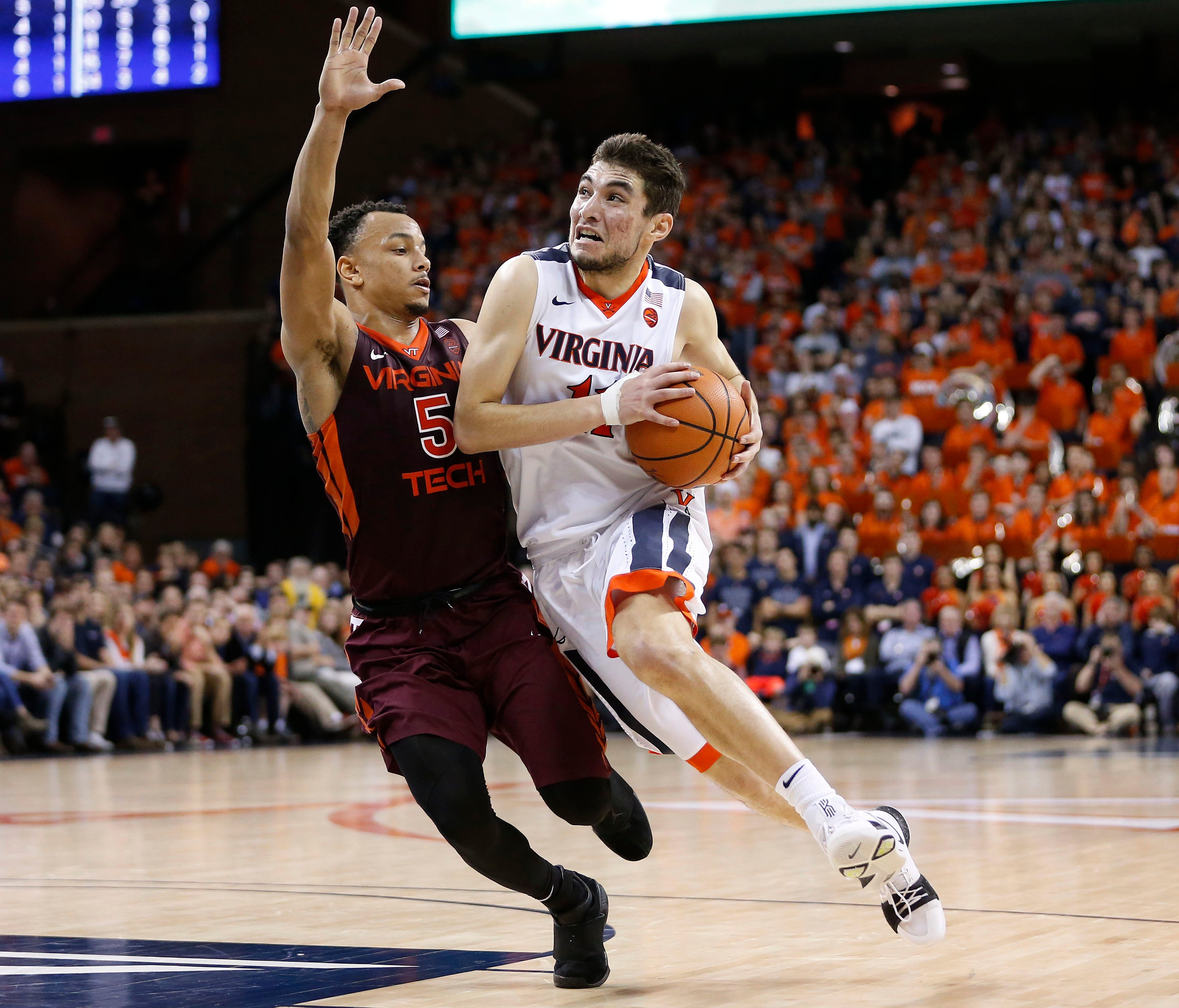Virginia guard Ty Jerome  dribbles the ball against the defense of Virginia Tech guard Justin Robinson.