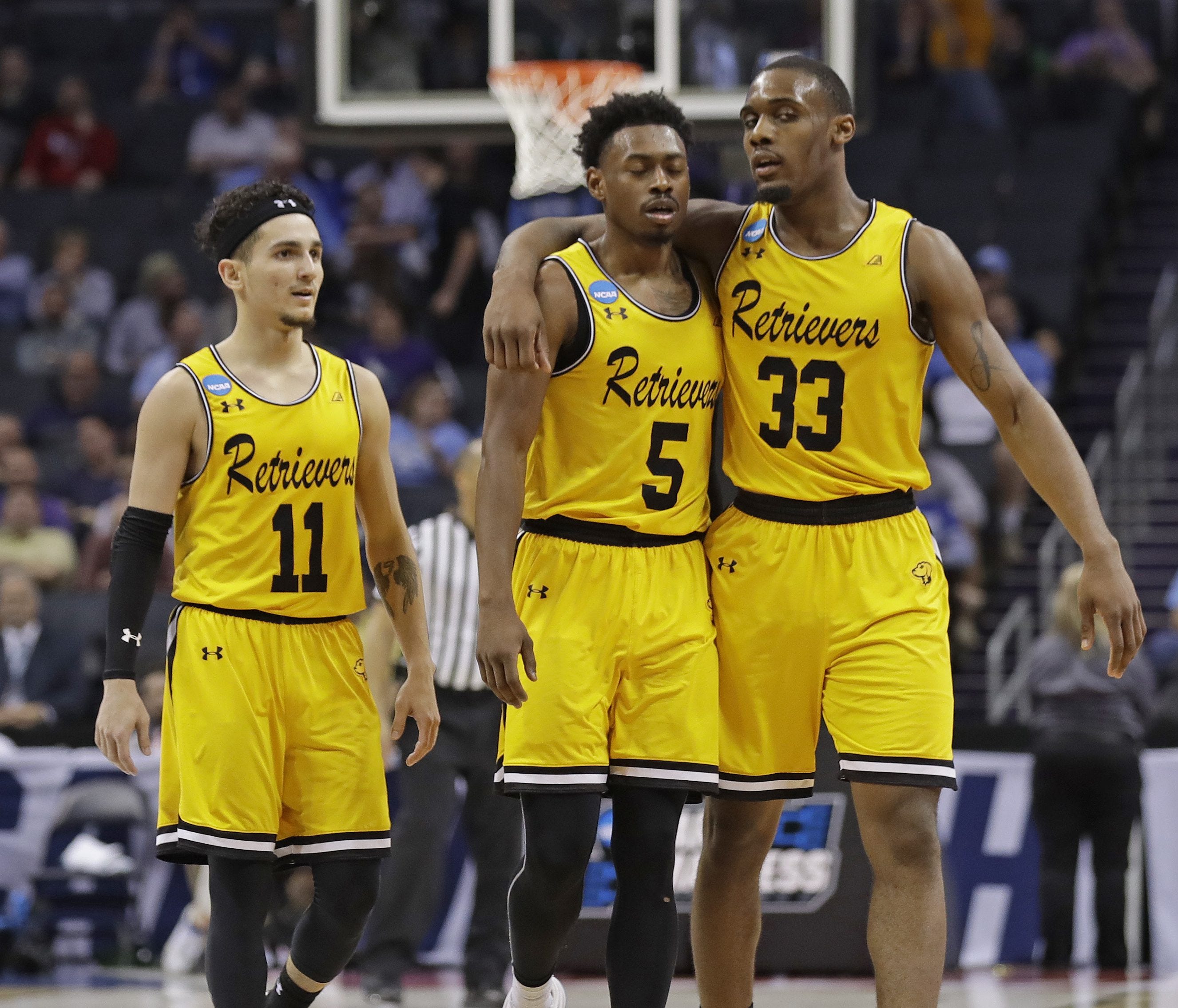 UMBC's Arkel Lamar, Jourdan Grant and K.J. Maura, from right, embrace as they leave the court in the closing moments of the team's 50-43 loss to Kansas State in a second-round game in the NCAA men's college basketball tournament in Charlotte, N.C., S