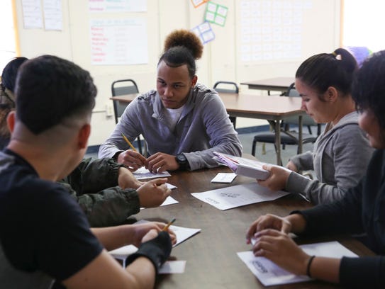 Misael Delgado, 17, works in a group during class at