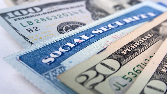 A Social Security card wedged between fanned cash bills.