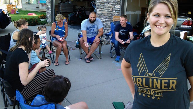 Several neighbors turned out for “drinks in the driveway” hosted recently by Rachel Schramm (right) at her North Liberty home – and arranged by her online.