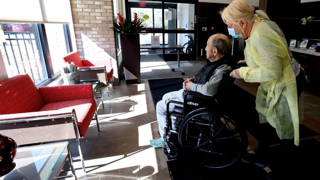 Johanna Mannone, 79 of Rochester Hills shows to her husband Michael Mannone where she parked at WellBridge of Rochester Hills, a skilled nursing and rehabilitation center in Rochester Hills, Michigan on Friday, March 13, 2020.  She was only able to visit her husband who has lived here for 6 months for a half hour.