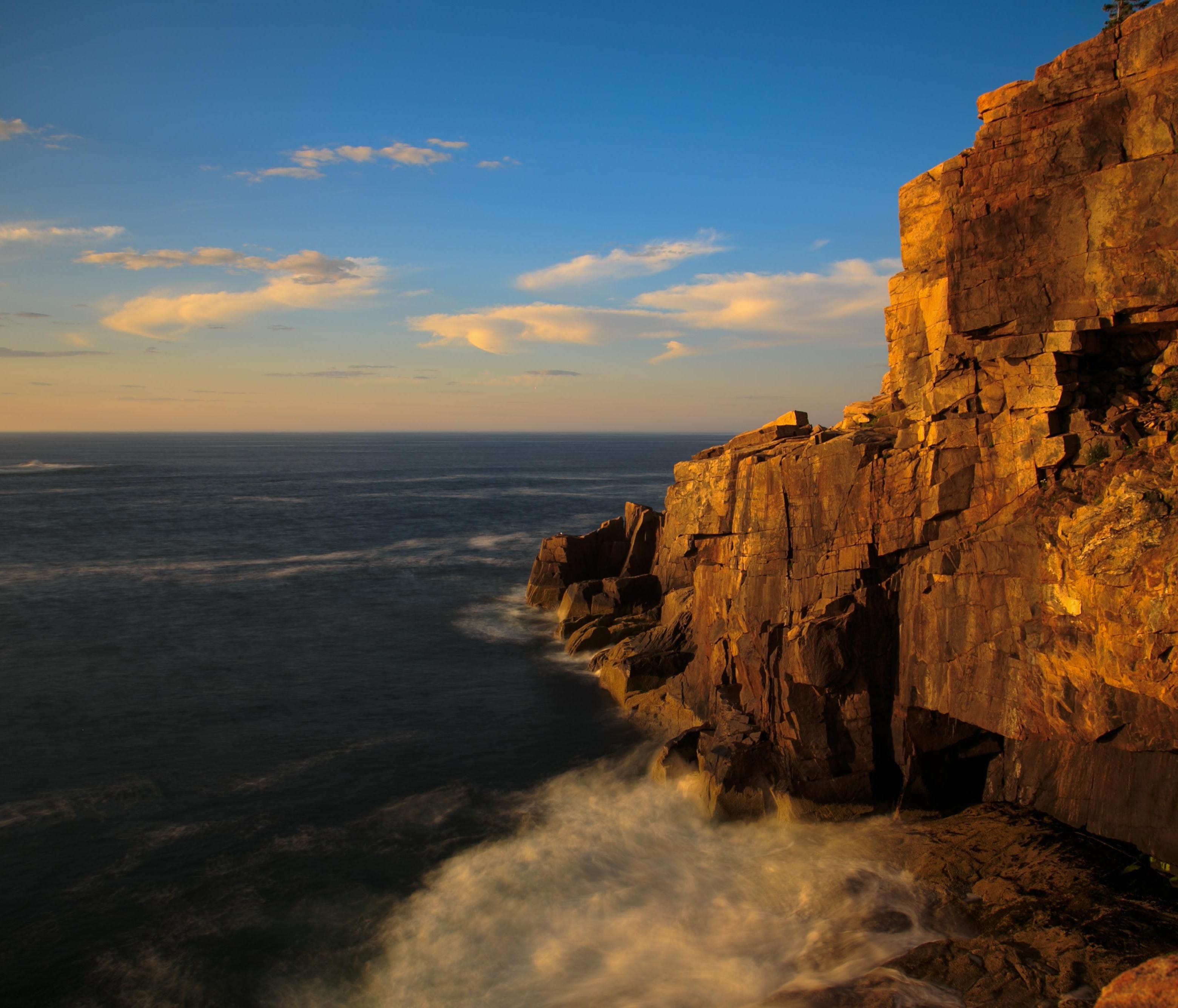 Sunrise turns Otter Cliff and the Atlantic spray pink along Ocean Drive at Acadia National Park. With the park located so far east, it has been dubbed the home of 