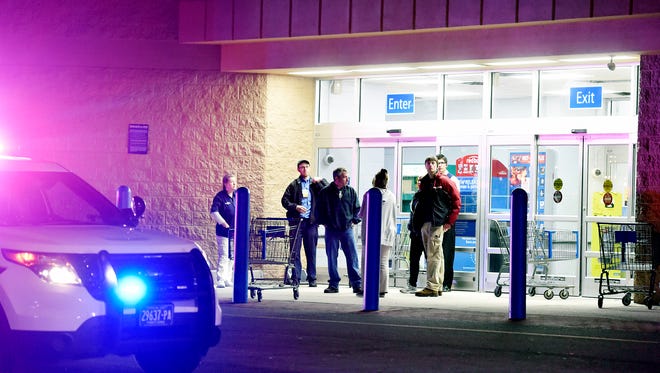 Store customers and employees wait outside after a shooting at Wal-Mart in Shrewsbury Township on April 7.