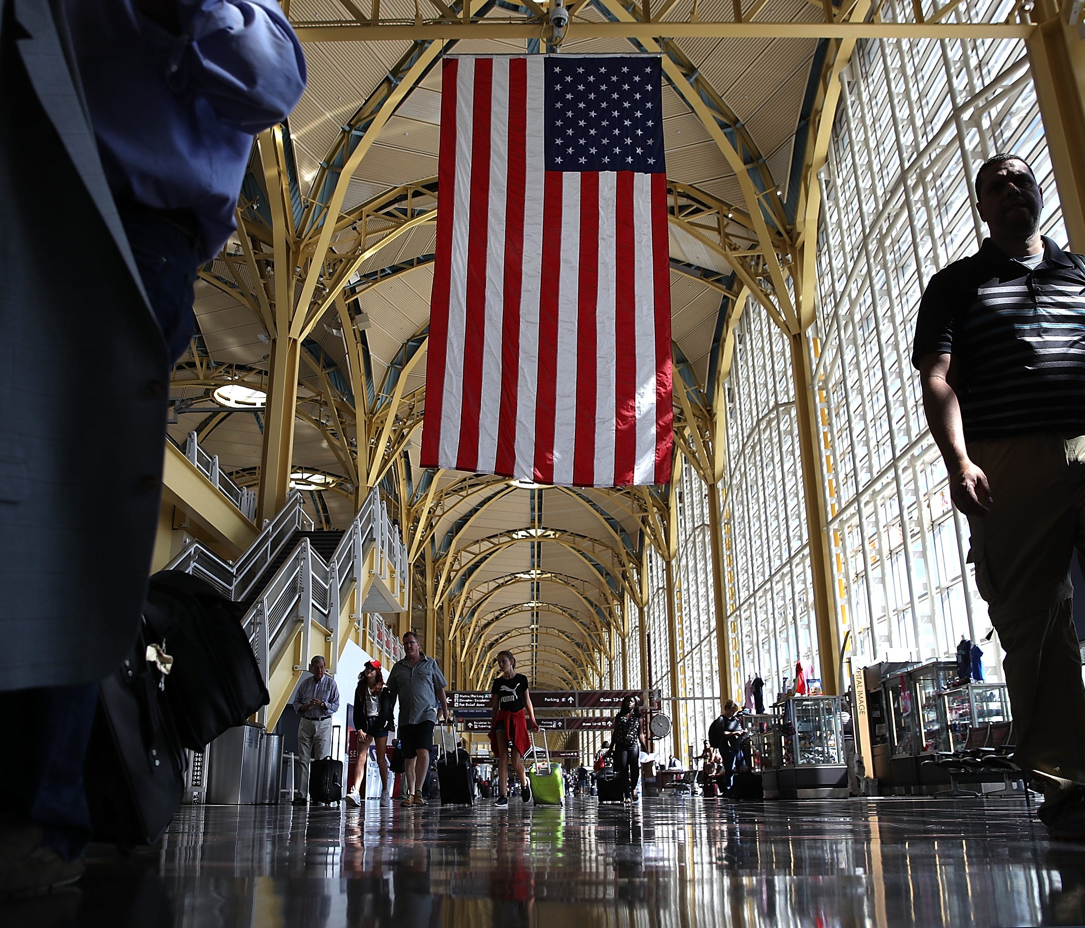 Travelers walk to their gates in the concourse of Reagan National Airport in advance of the Fourth of July holiday.